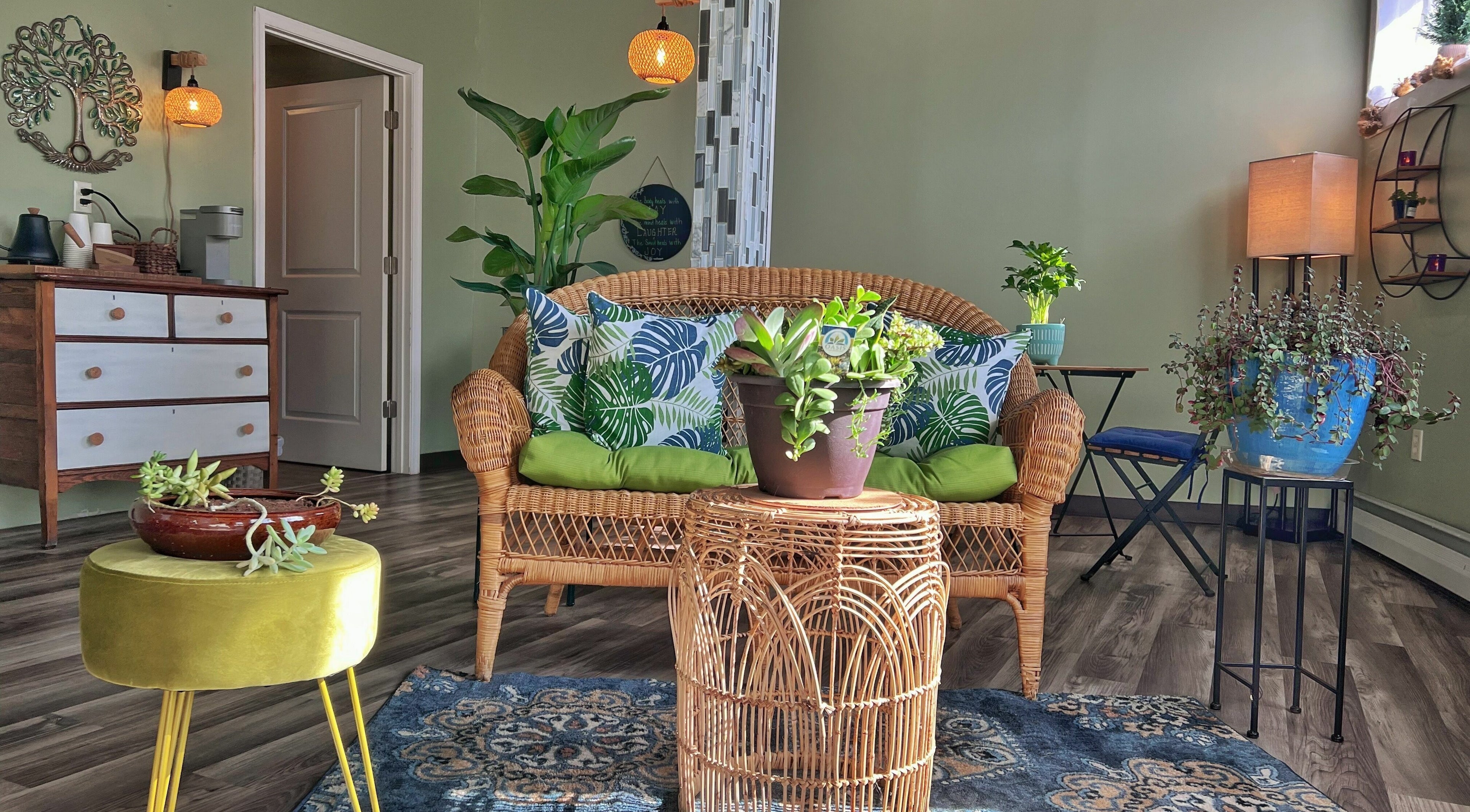 Cozy seating area at Now and Zen Wellness LLC in Throop, Pennsylvania, US with plants and wicker furniture.