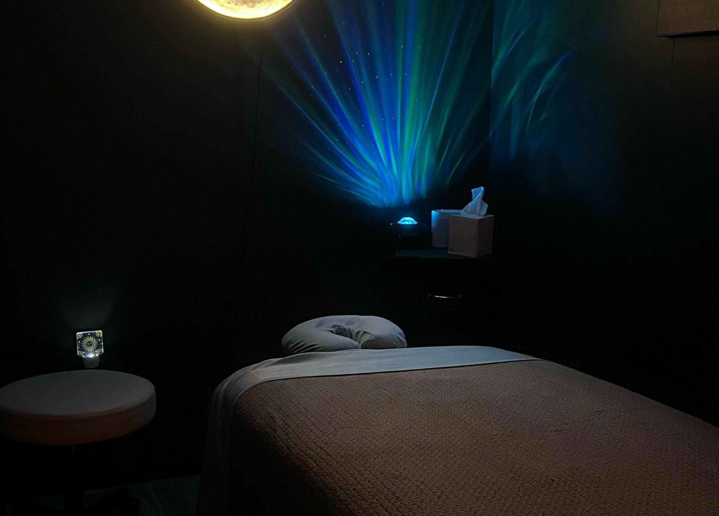 A serene massage room at Now and Zen Wellness LLC, Throop, Pennsylvania, US, featuring ambient lighting.