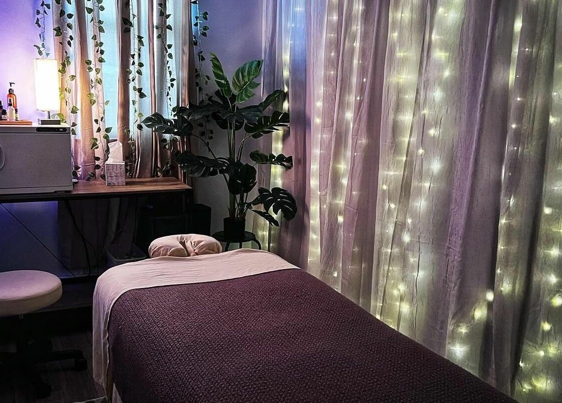 A serene massage room at Now and Zen Wellness LLC, Throop, Pennsylvania, US, decorated with plants and soft lighting.