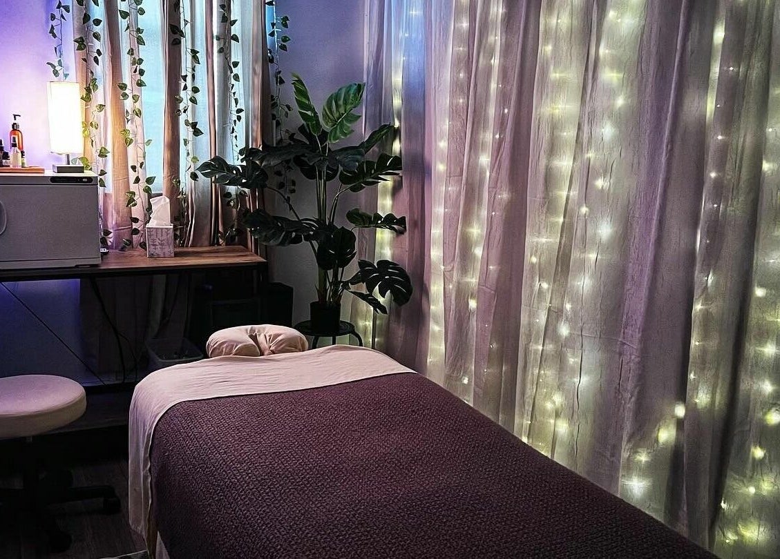 A serene massage room at Now and Zen Wellness LLC, Throop, Pennsylvania, US, decorated with plants and soft lighting.