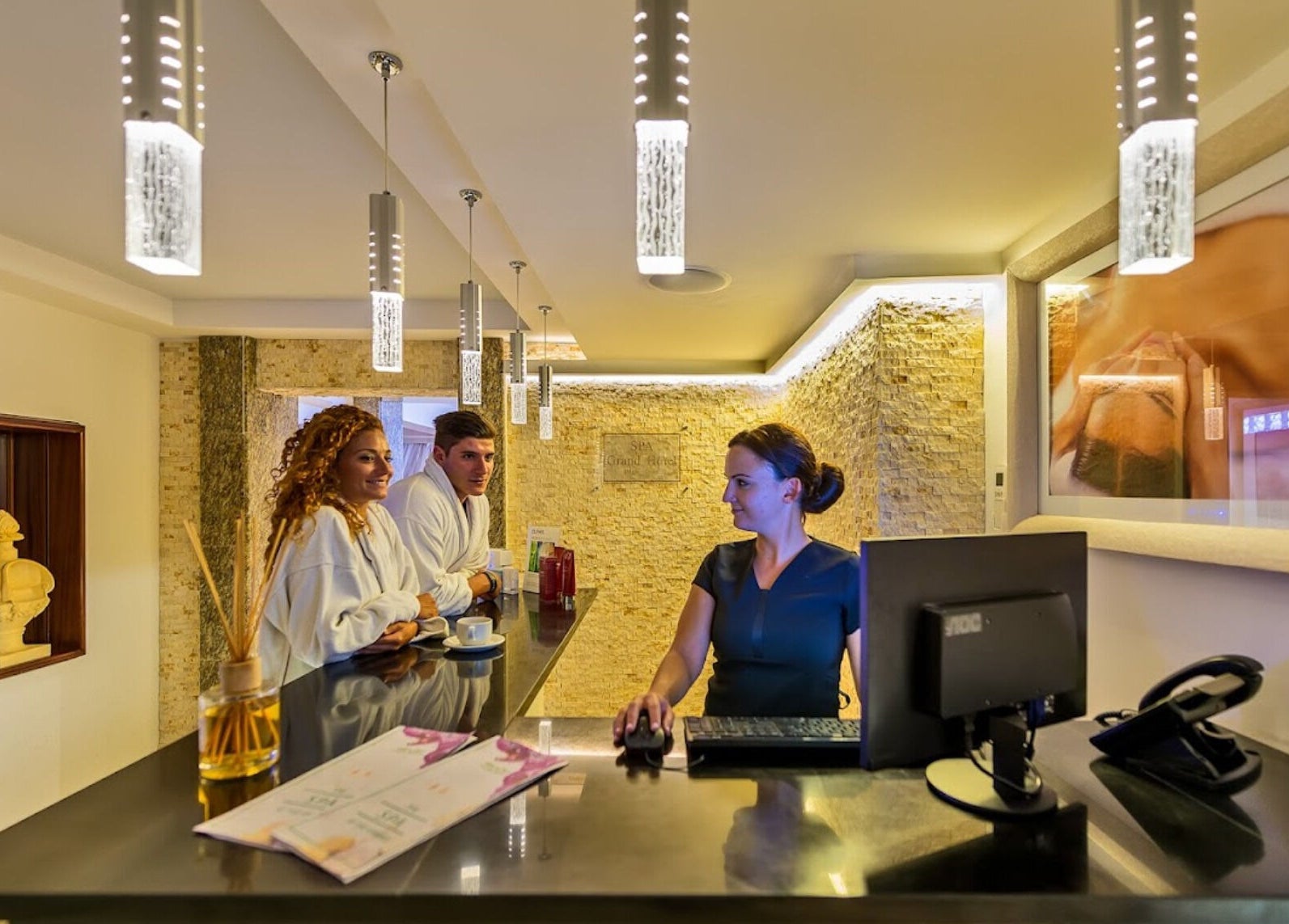 Guests enjoy a warm welcome at The Grand Hotel Elemis Spa, Gozo, MT's serene reception area.