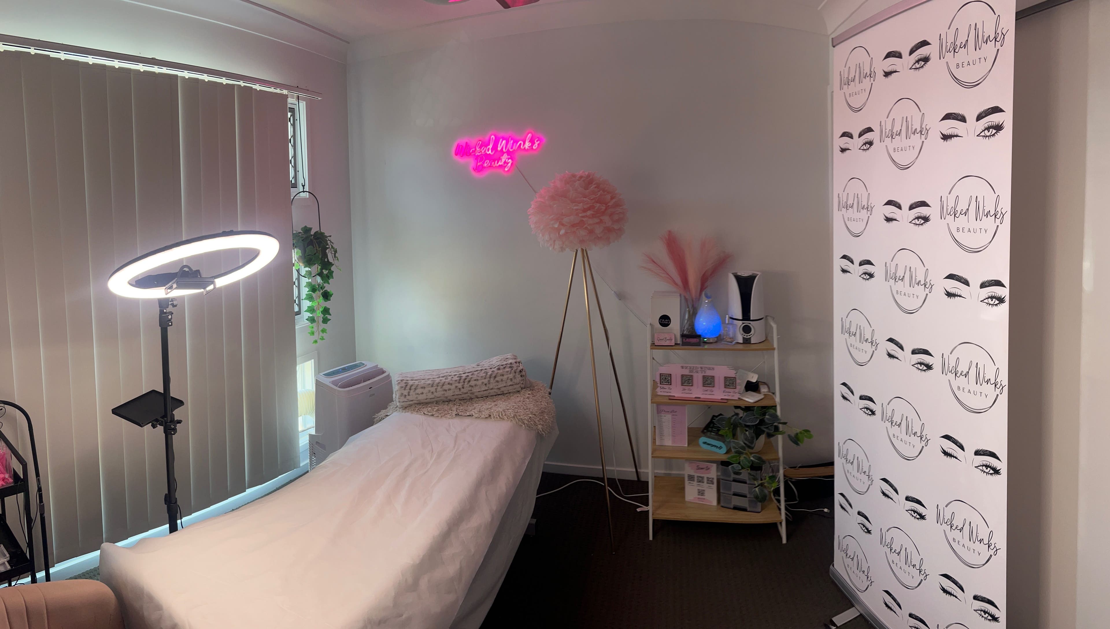Cozy treatment room at Wicked Winks Beauty in Burpengary, Queensland, AU with neon sign and elegant decor.