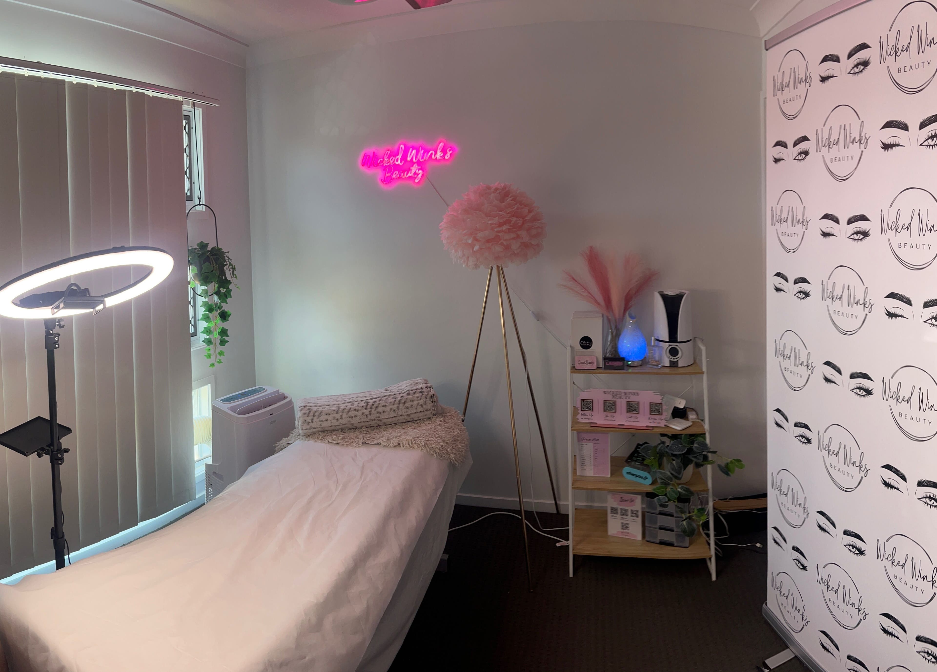 Cozy treatment room at Wicked Winks Beauty in Burpengary, Queensland, AU with neon sign and elegant decor.