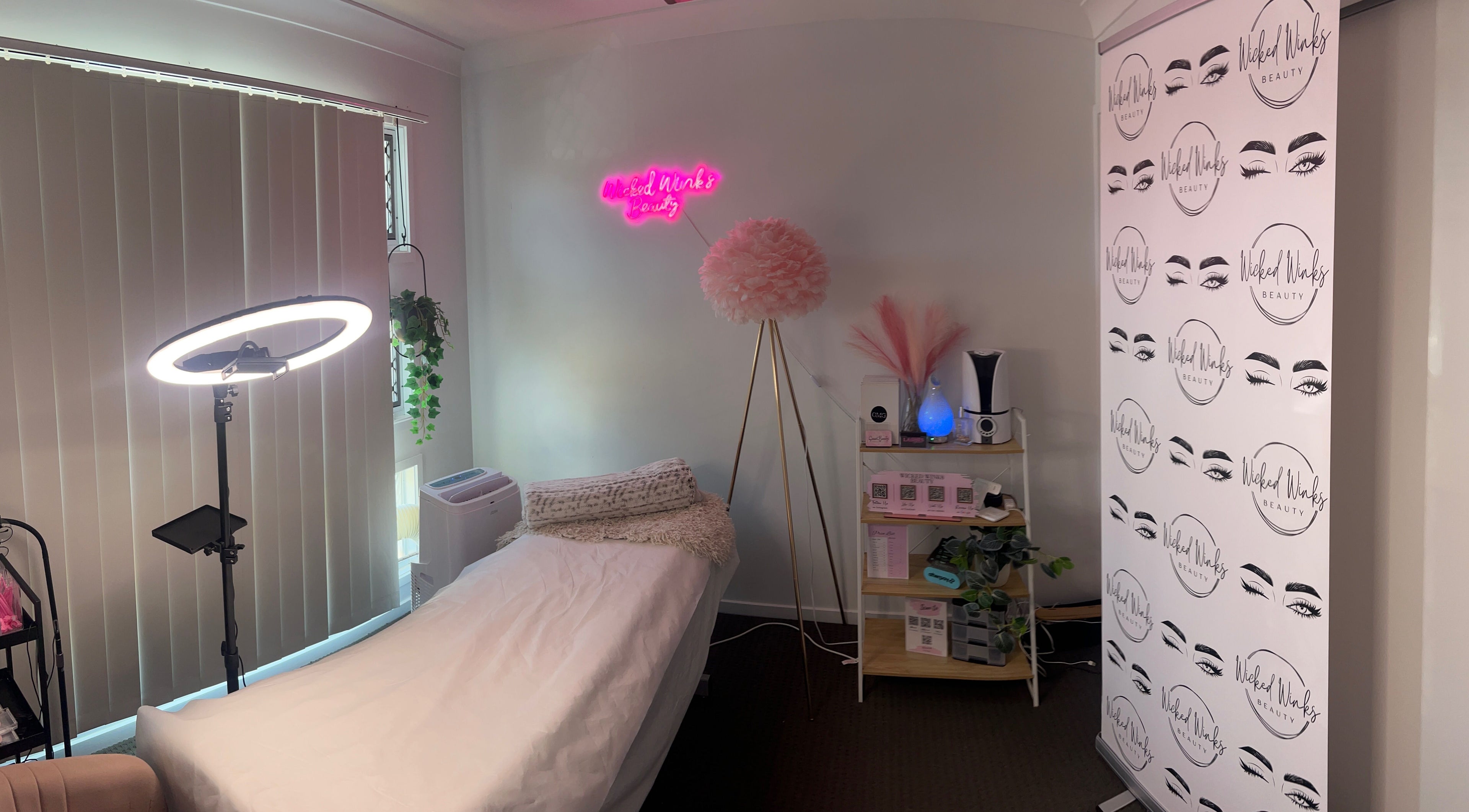 Cozy treatment room at Wicked Winks Beauty in Burpengary, Queensland, AU with neon sign and elegant decor.