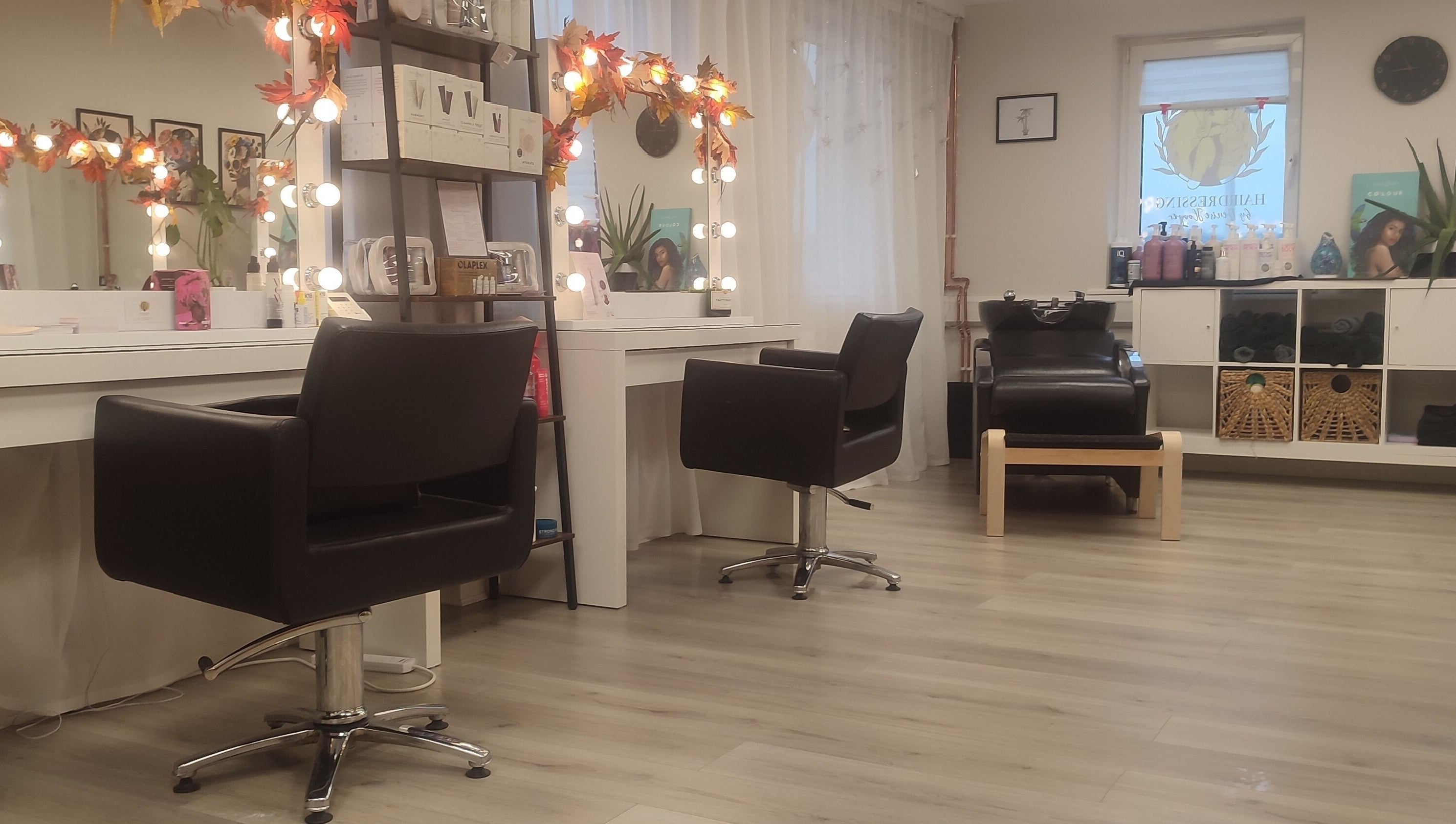 Elegant interior of Jessica Gilbert Hair salon in Corbridge, England with stylish chairs and lit mirrors.