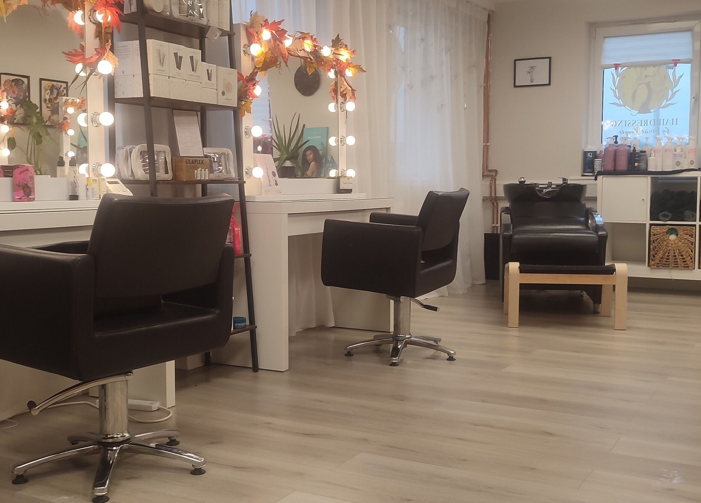 Elegant interior of Jessica Gilbert Hair salon in Corbridge, England with stylish chairs and lit mirrors.