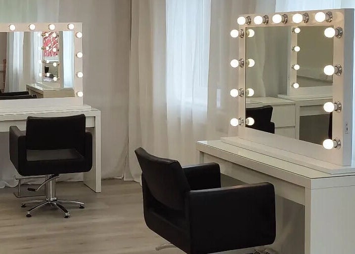 Elegant vanity setup at Jessica Gilbert Hair in Corbridge, England, GB with illuminated mirrors and chairs.
