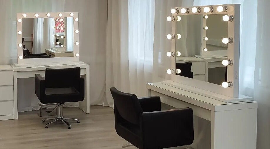Elegant vanity setup at Jessica Gilbert Hair in Corbridge, England, GB with illuminated mirrors and chairs.