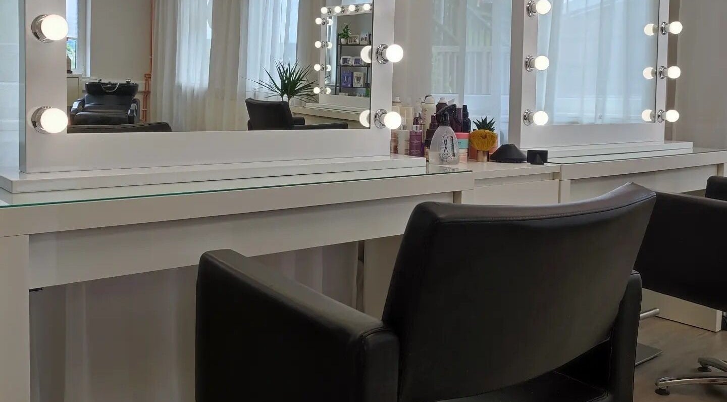 Elegant salon station at Jessica Gilbert Hair in Corbridge, England, GB, featuring chic styling chairs and mirrors.