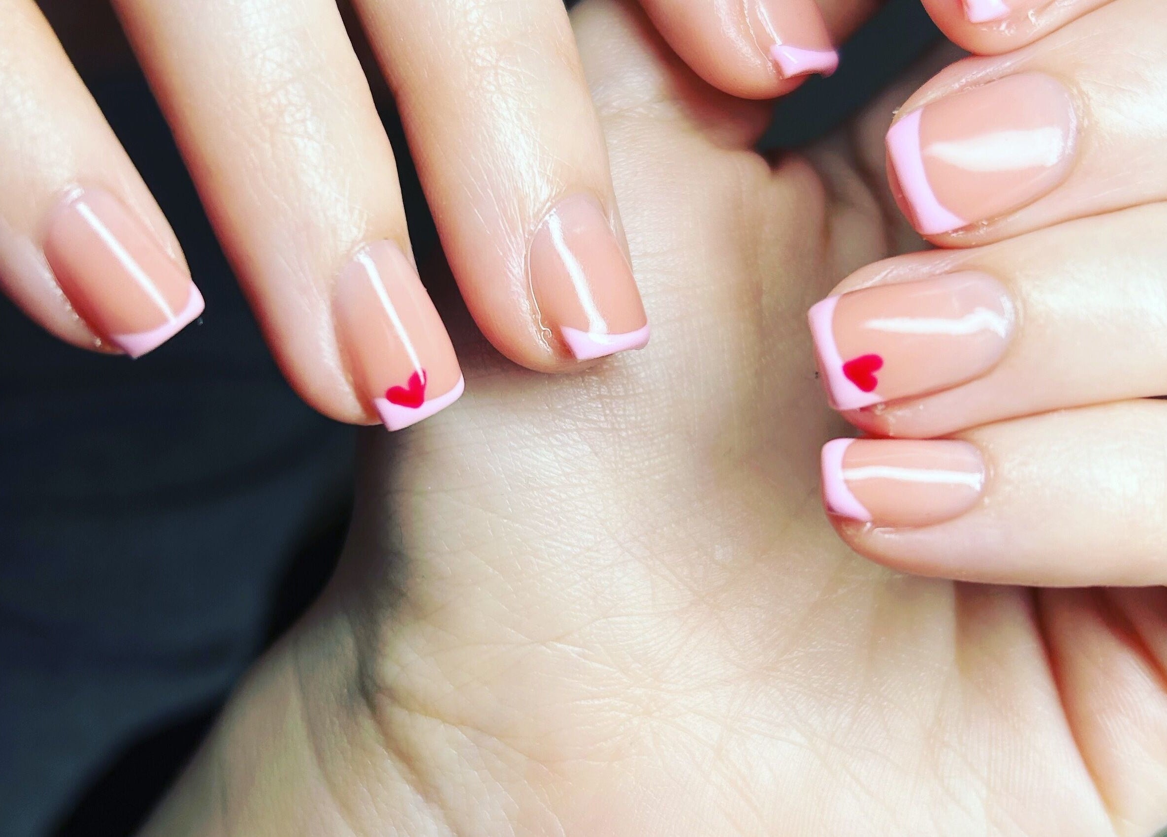 Pink-tipped nails with heart design at Nails By Jade, Canvey Island, England, GB.