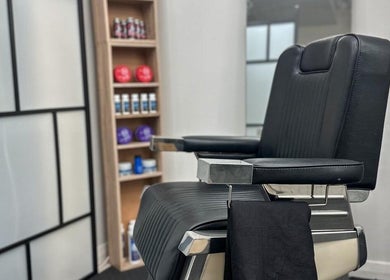 Modern barber chair at Quinche Studio in Mascot, New South Wales, AU with grooming products in the background.