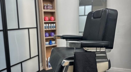 Modern barber chair at Quinche Studio in Mascot, New South Wales, AU with grooming products in the background.