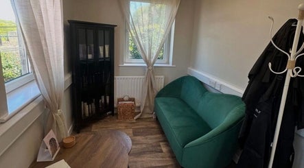Cozy lounge area at Hair by Zoe Fellows, featuring a green sofa in Corbridge, England, GB.
