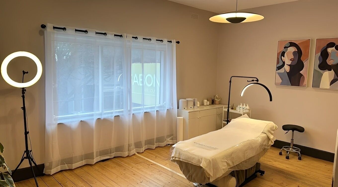 Relaxing spa room at Just Beaute, Melbourne, Victoria, AU, featuring a massage bed and soft lighting.