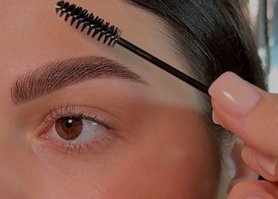 Eyebrow grooming at Beauty Bar by Kate in Manchester, England, GB using a brush tool for precision shaping.