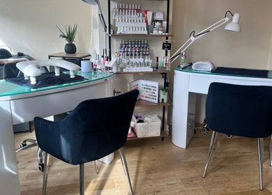 Modern nail stations at Absolute Salon in Valley, Wales, GB featuring sleek tables and black chairs.