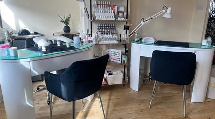 Modern nail stations at Absolute Salon in Valley, Wales, GB featuring sleek tables and black chairs.