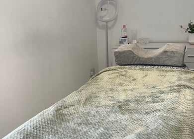 Cozy treatment room at Absolute Salon, Valley, Wales, GB. Features a cushioned bed and serene decor.