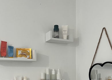 Beauty products on shelves with a heart mirror at Absolute Salon, Valley, Wales, GB.