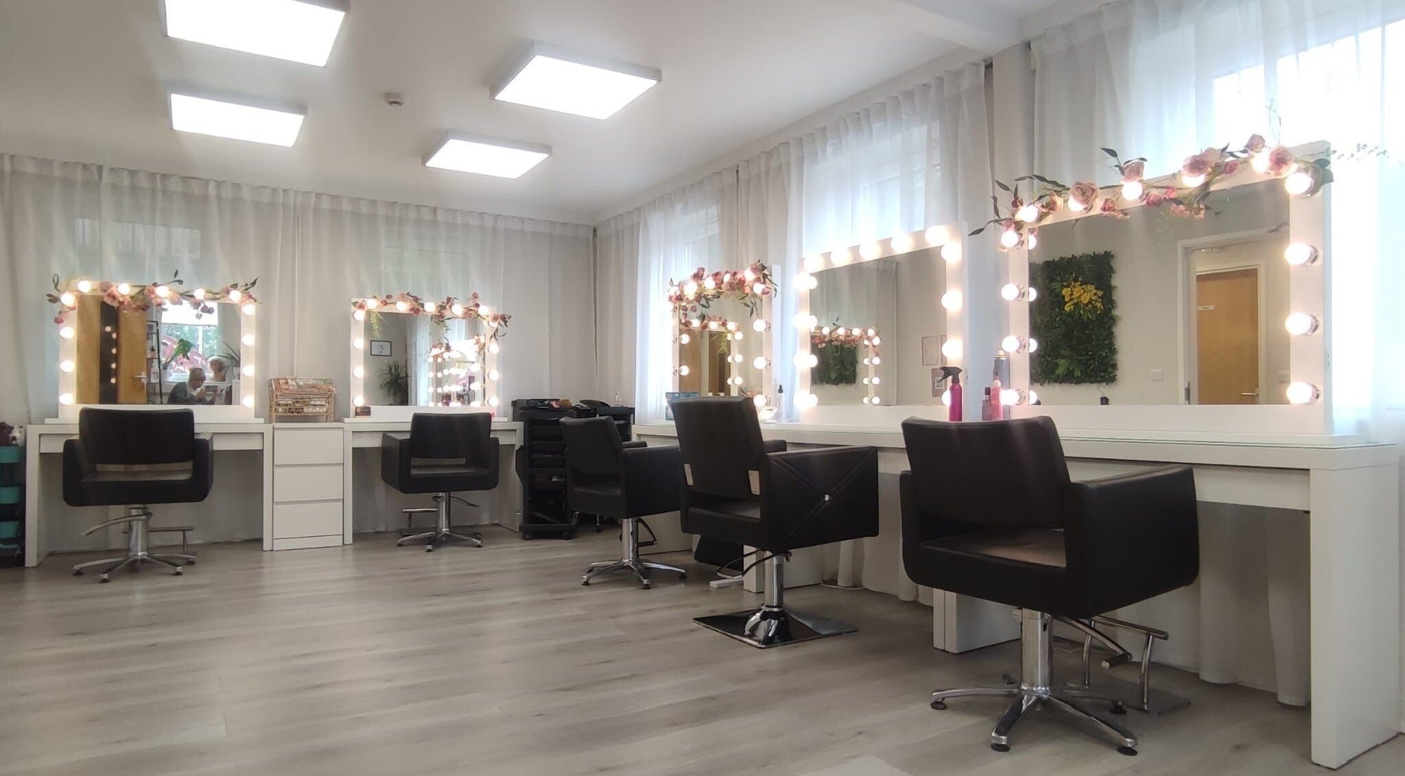 Modern hair styling stations at Pam Ward Hair in Corbridge, England, GB with lit mirrors and chic decor.
