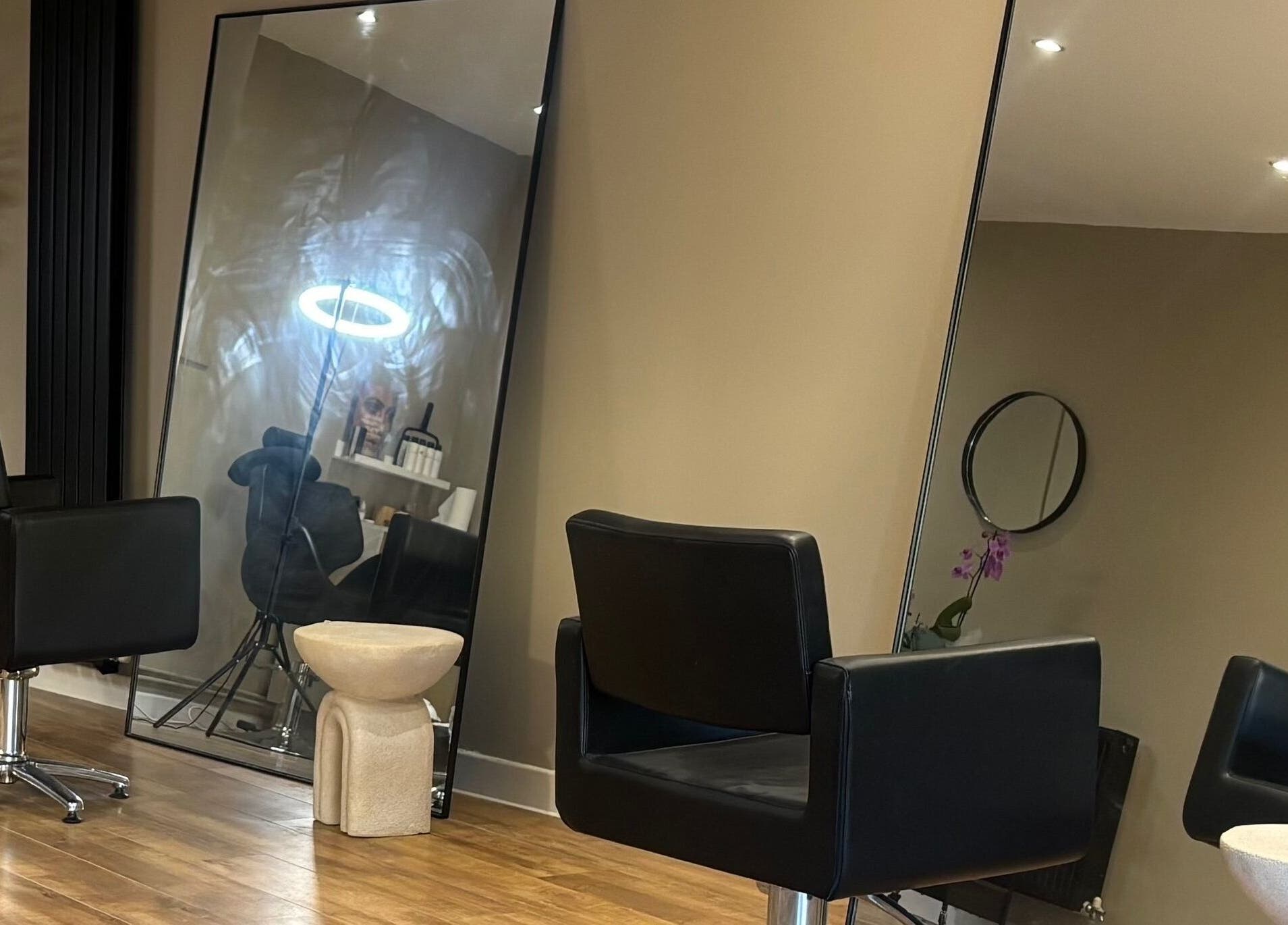 Modern salon interior at Cloud Studio, Livingston, Scotland, GB with sleek black chairs and large mirrors.