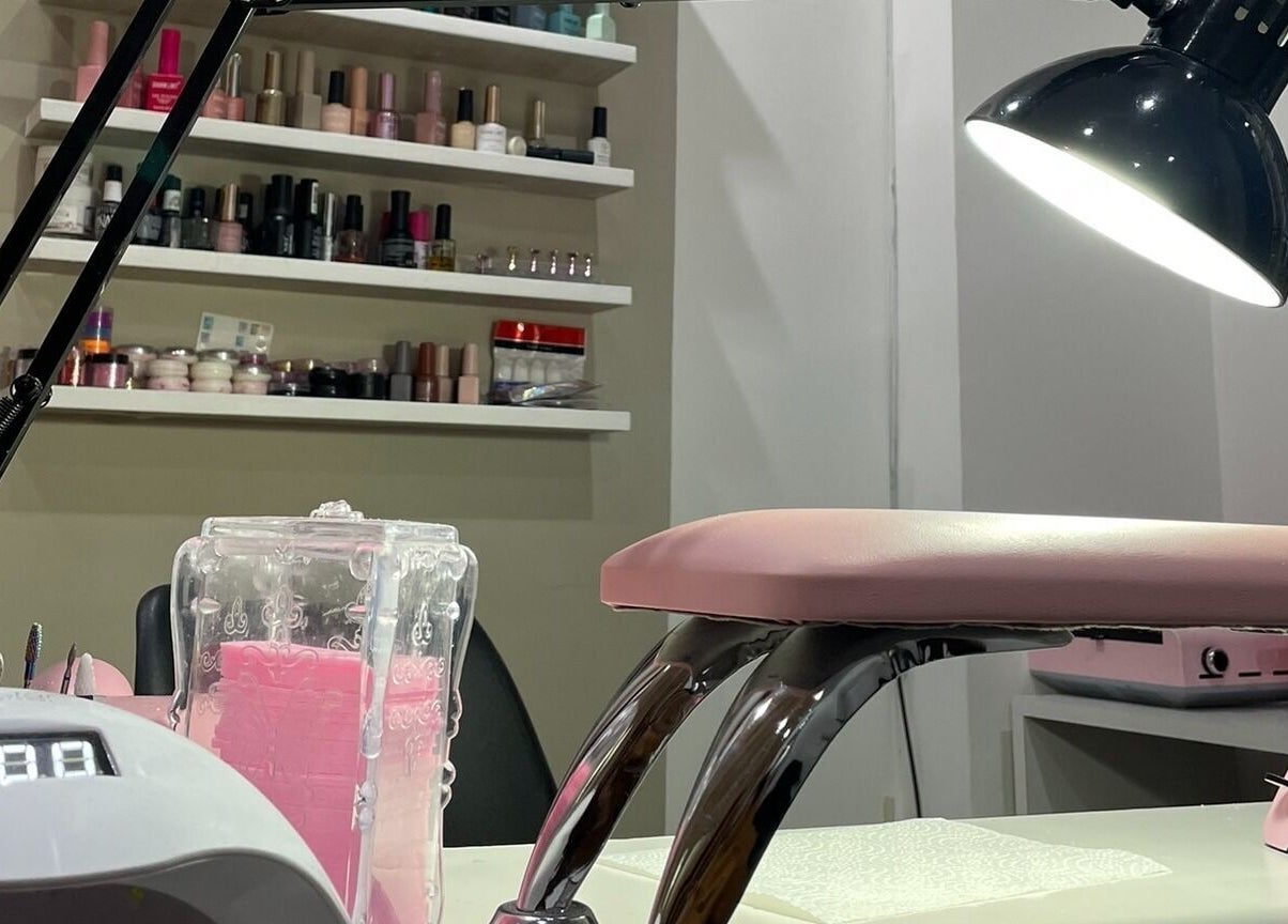 Estación de manicura en Lauris Fernández Studio, Mendoza, Mendoza, AR, con lámpara y esmaltes coloridos.