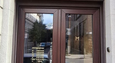 Elegant entrance of NailBerry in Budapest, Magyar, HU with clear glass doors and wooden frame.