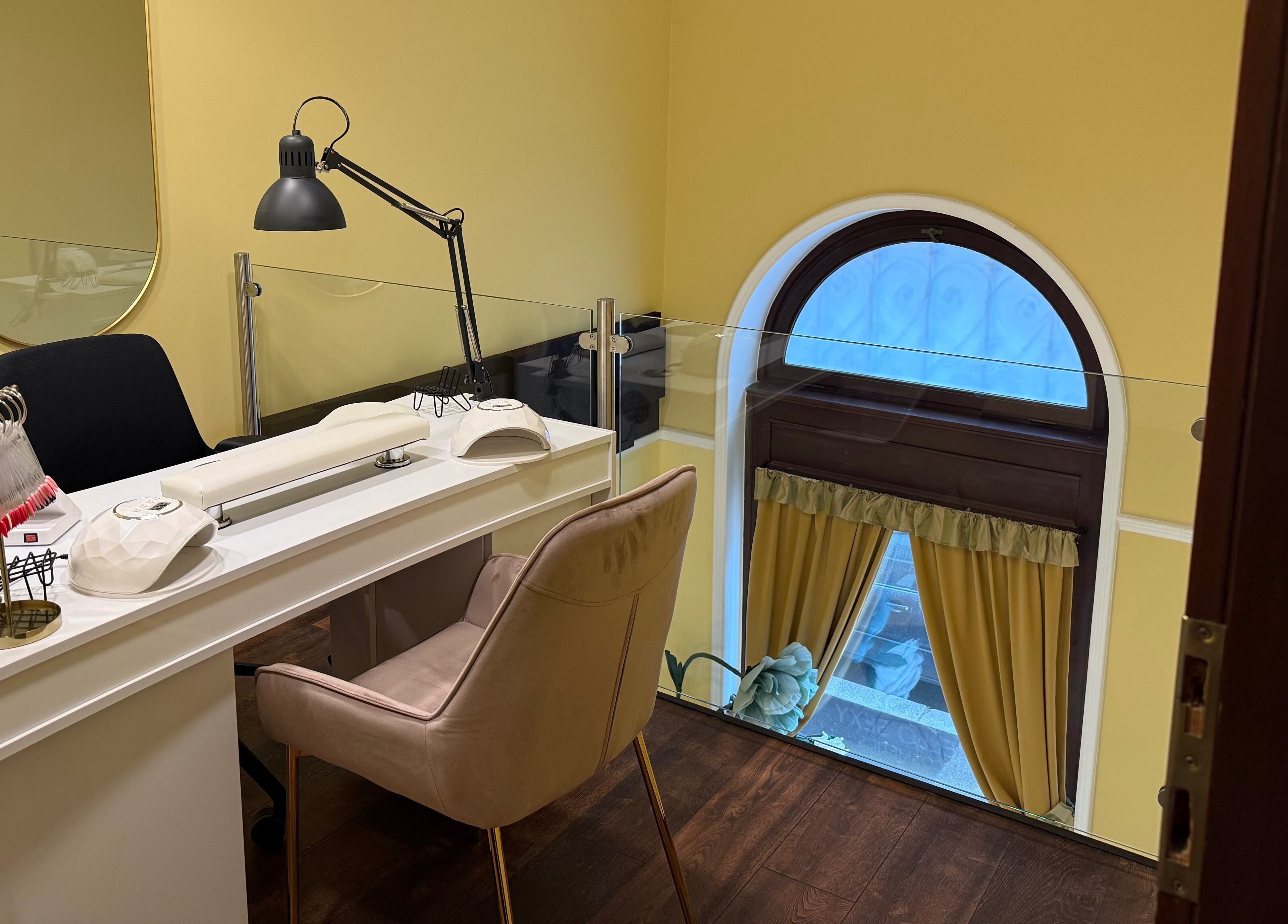 Sophisticated nail desk setup at Nail Berry, Budapest, Magyar, HU, featuring plush seating and modern decor.