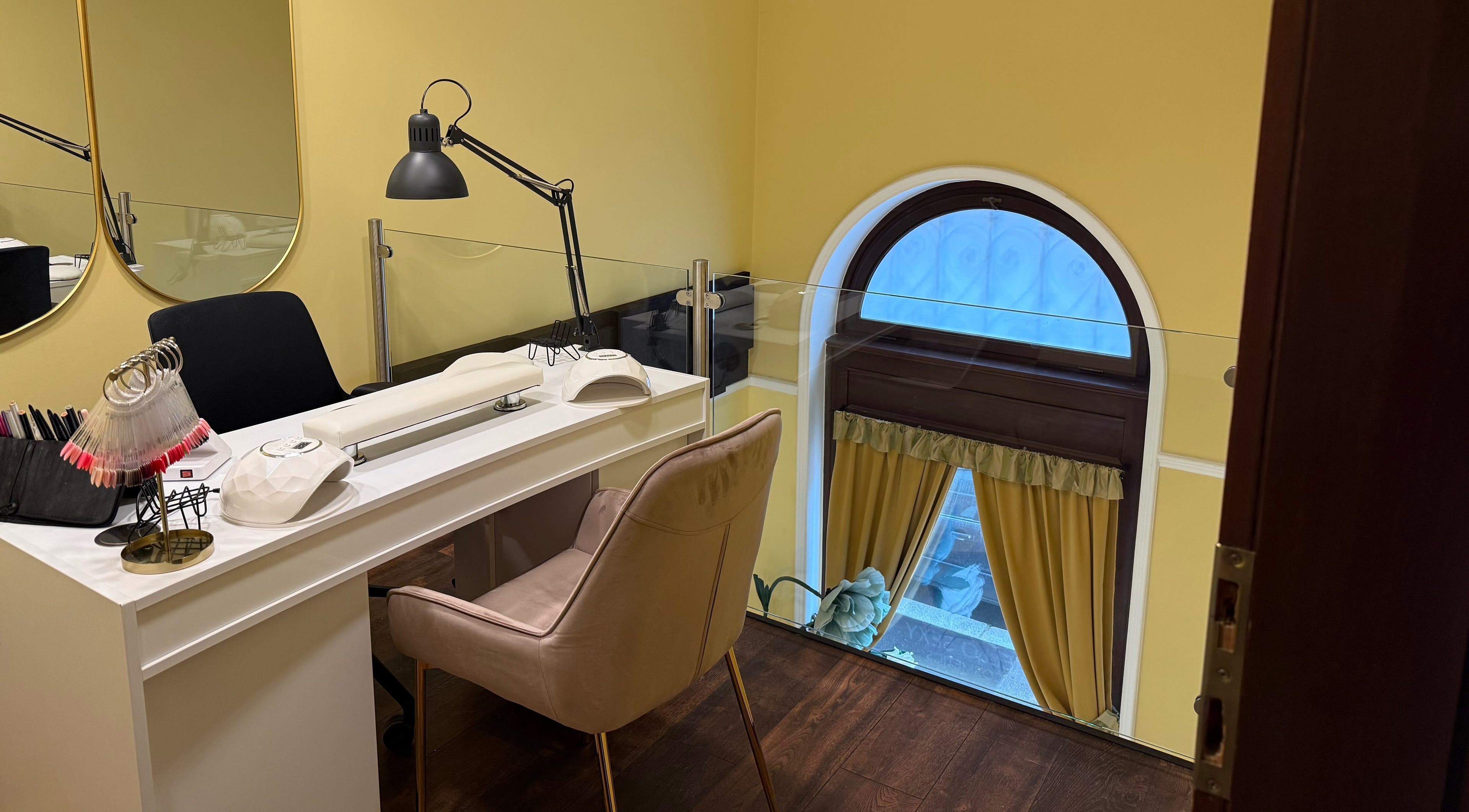 Sophisticated nail desk setup at Nail Berry, Budapest, Magyar, HU, featuring plush seating and modern decor.