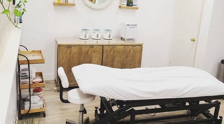 Modern treatment room at Sugar It Beauty, San Diego, California, US with a cushioned bed and wooden decor.