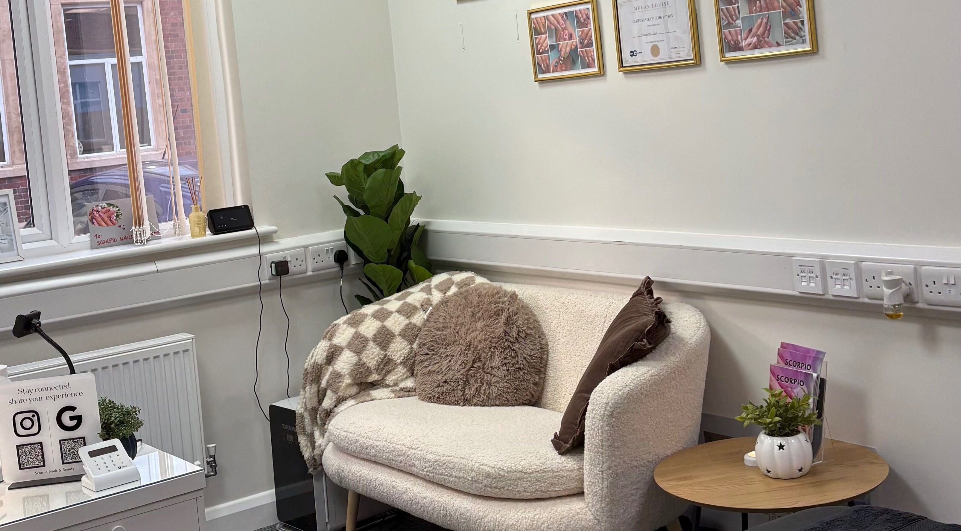 Relaxing seating area at Scorpio Nails & Beauty, Doncaster, England, GB with elegant decor and lush plant.