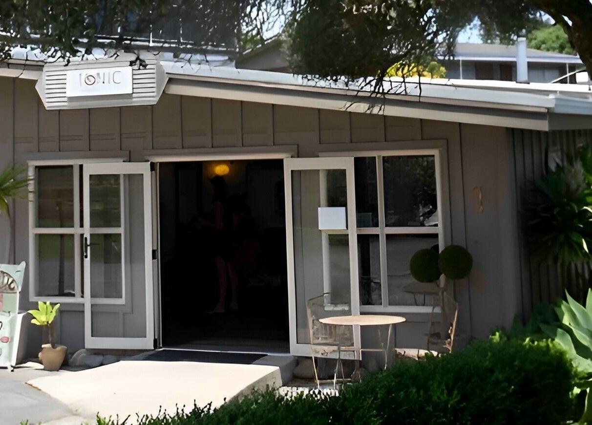 Charming exterior of Tonic Hairdressing in Raglan, Waikato, NZ. A welcoming salon entry surrounded by greenery.