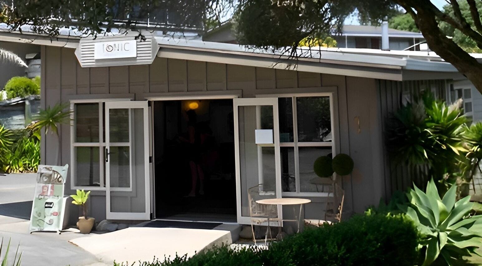 Charming exterior of Tonic Hairdressing in Raglan, Waikato, NZ. A welcoming salon entry surrounded by greenery.