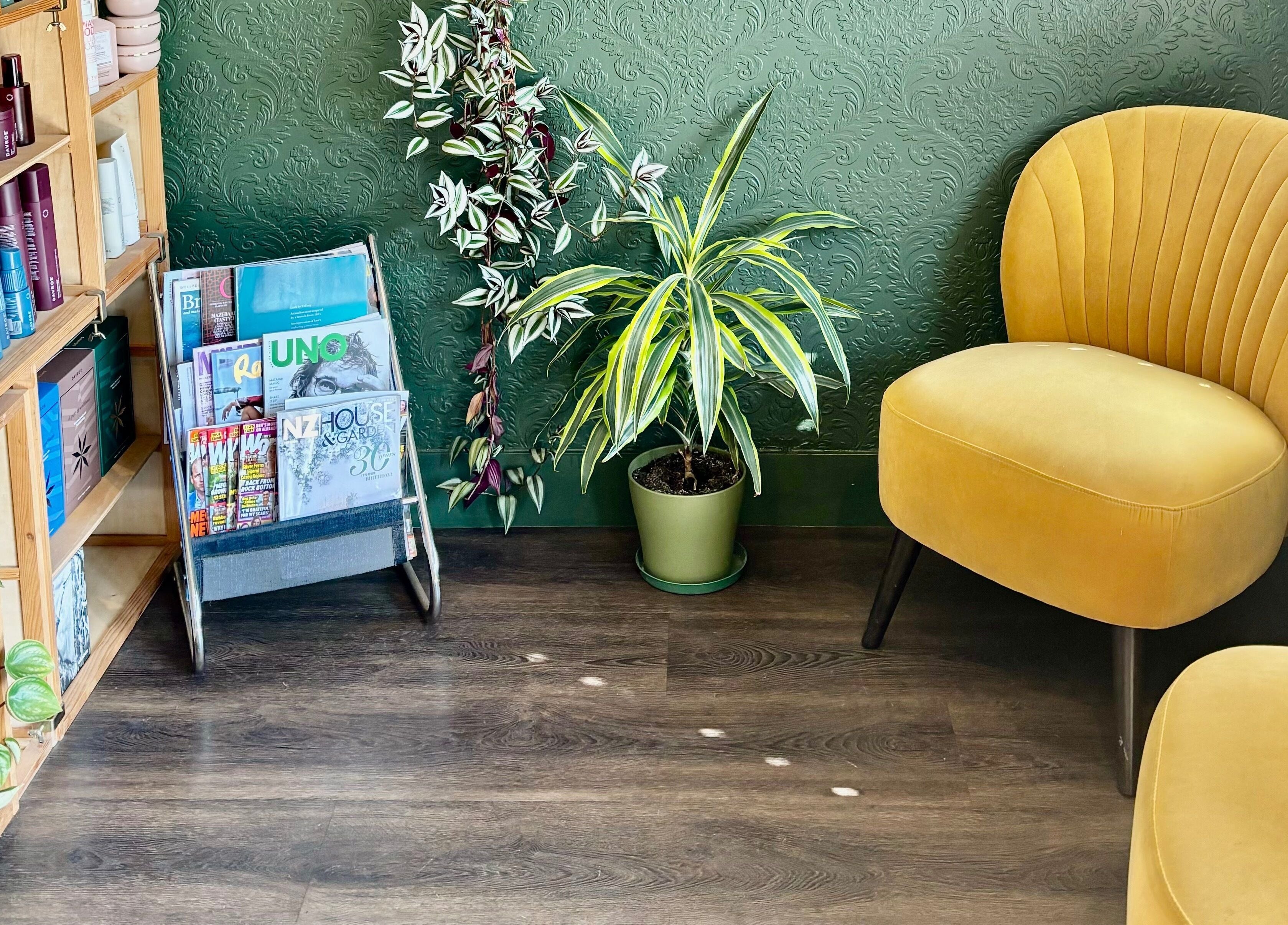 Cozy corner with yellow chair and plants at Tonic Hairdressing, Raglan, Waikato, NZ.