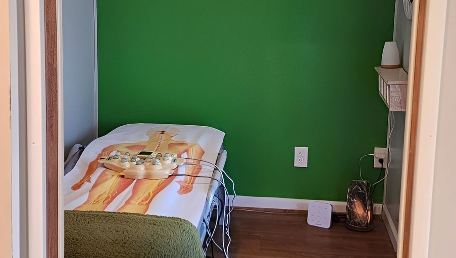 Therapy room at Green Room Remedies, Get Me Some Green, Matthews, NC, featuring treatment bed and serene ambiance.