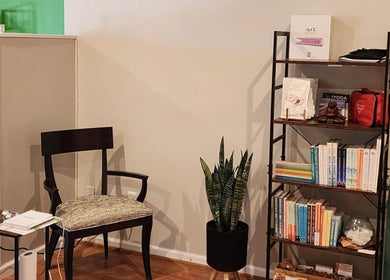 Cozy reading nook at Green Room Remedies at Get Me Some Green in Matthews, North Carolina, US with shelf and chair.
