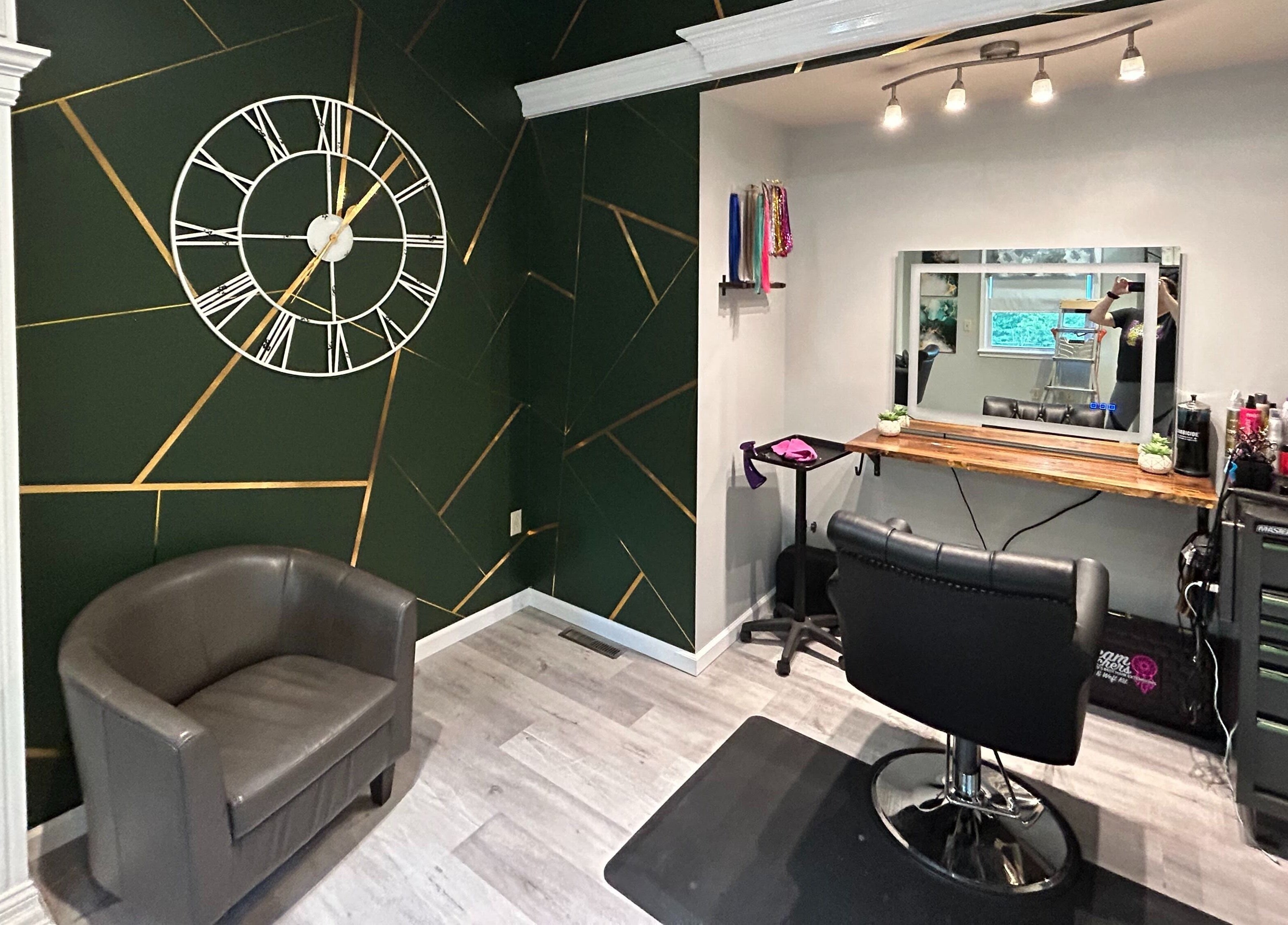 Modern salon chair and decor at Emerald Salon, Harrisonville, Missouri, US with a stylish geometric wall clock.
