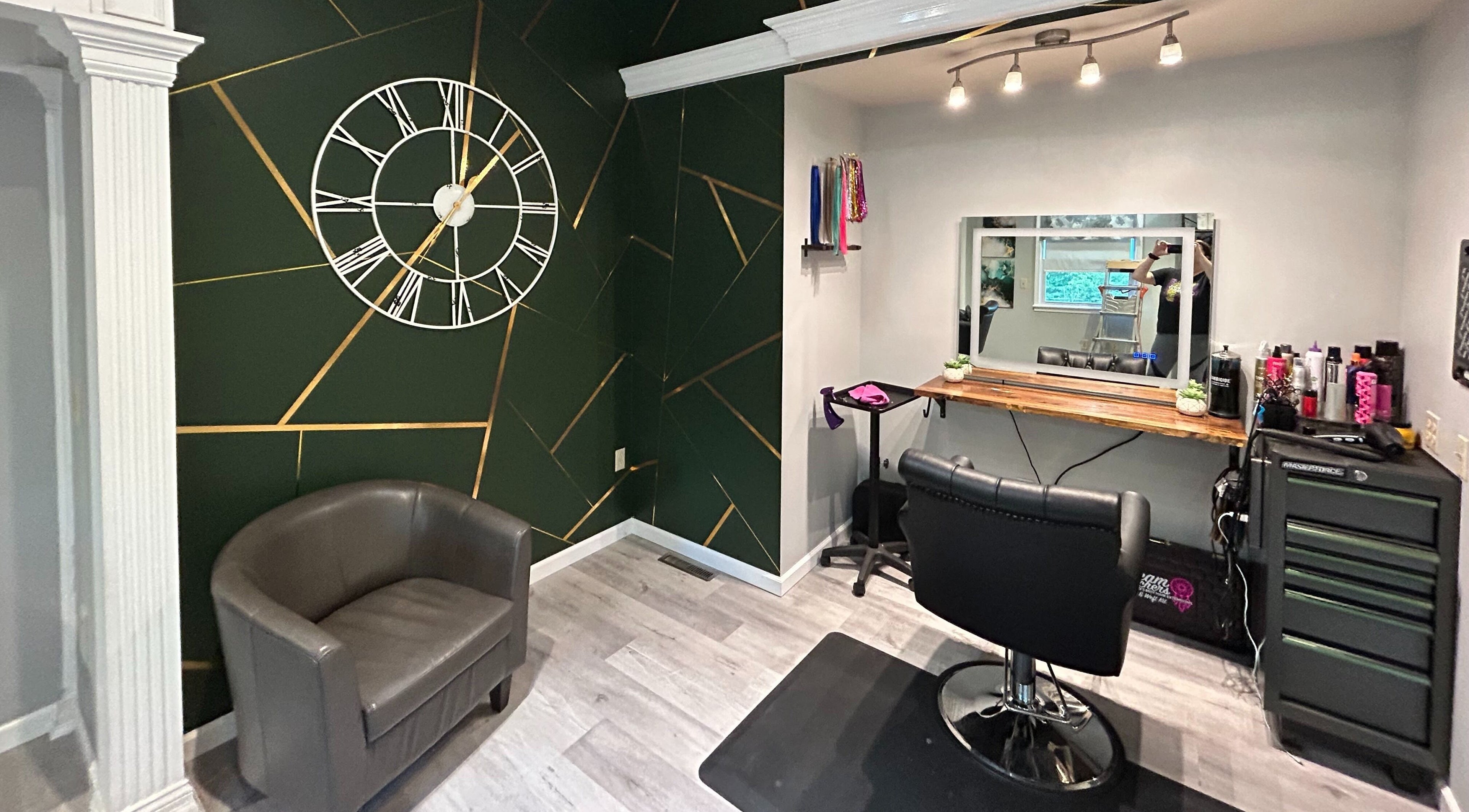 Modern salon chair and decor at Emerald Salon, Harrisonville, Missouri, US with a stylish geometric wall clock.