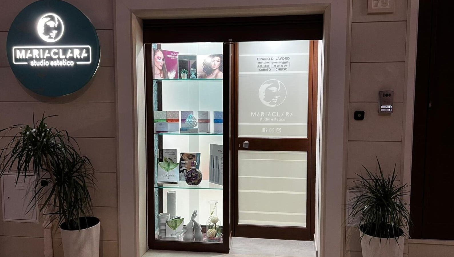 Ingresso illuminato di Mariaclara Studio Estetico a Ribera, Sicilia, IT, con piante e insegne attraenti.