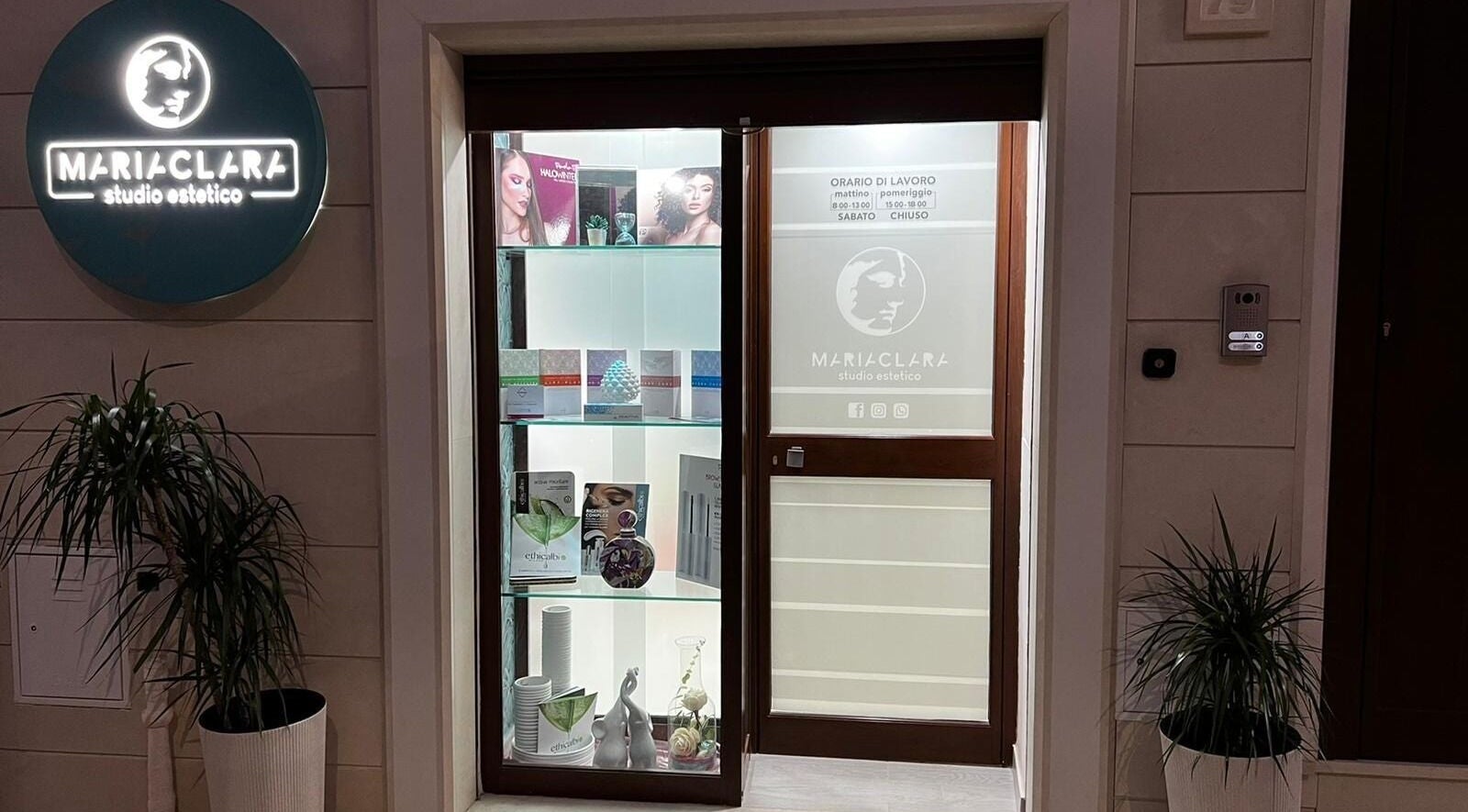 Ingresso illuminato di Mariaclara Studio Estetico a Ribera, Sicilia, IT, con piante e insegne attraenti.
