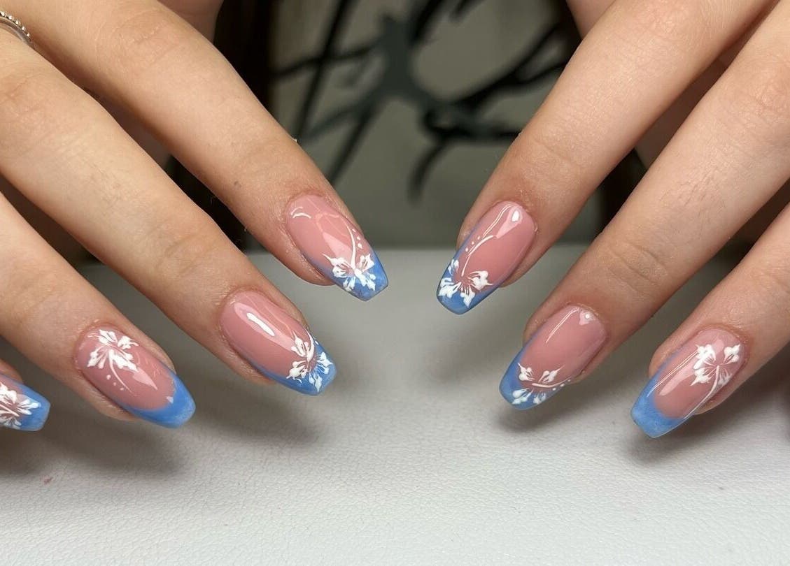 Eleganti unghie decorate con fiori bianchi e bordi blu a Mariaclara Studio Estetico, Ribera, Sicilia, IT.