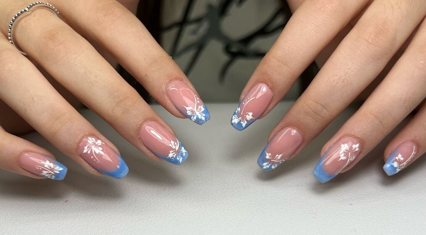 Eleganti unghie decorate con fiori bianchi e bordi blu a Mariaclara Studio Estetico, Ribera, Sicilia, IT.