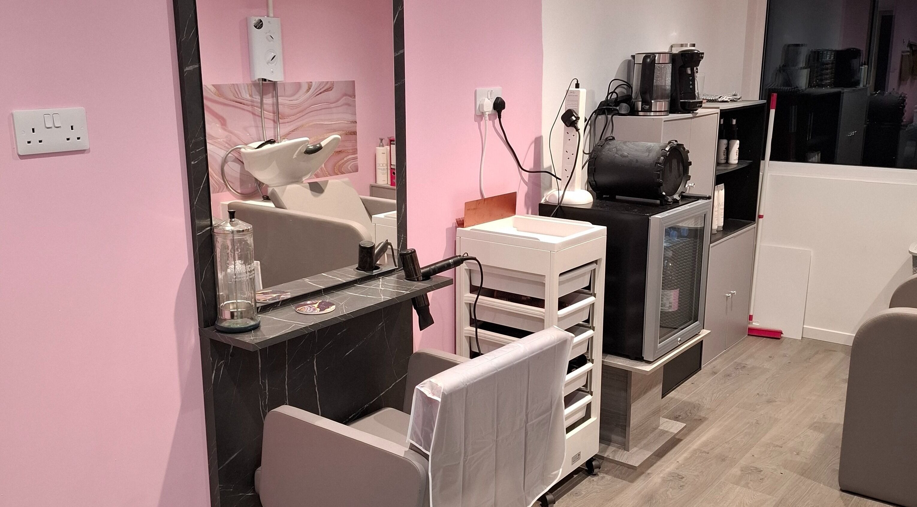 Modern salon station at H Gcreativehair in Plymouth, England, GB with pink walls and sleek equipment.