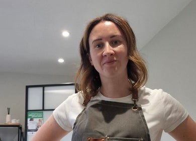 Friendly stylist in apron at Beauty by Leanne, Timperley, England, GB, ready to assist clients.