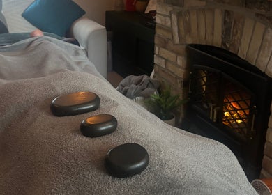 Hot stone massage at Pembrokeshire Sports Massage, Begelly, Wales, GB by a cozy fire.
