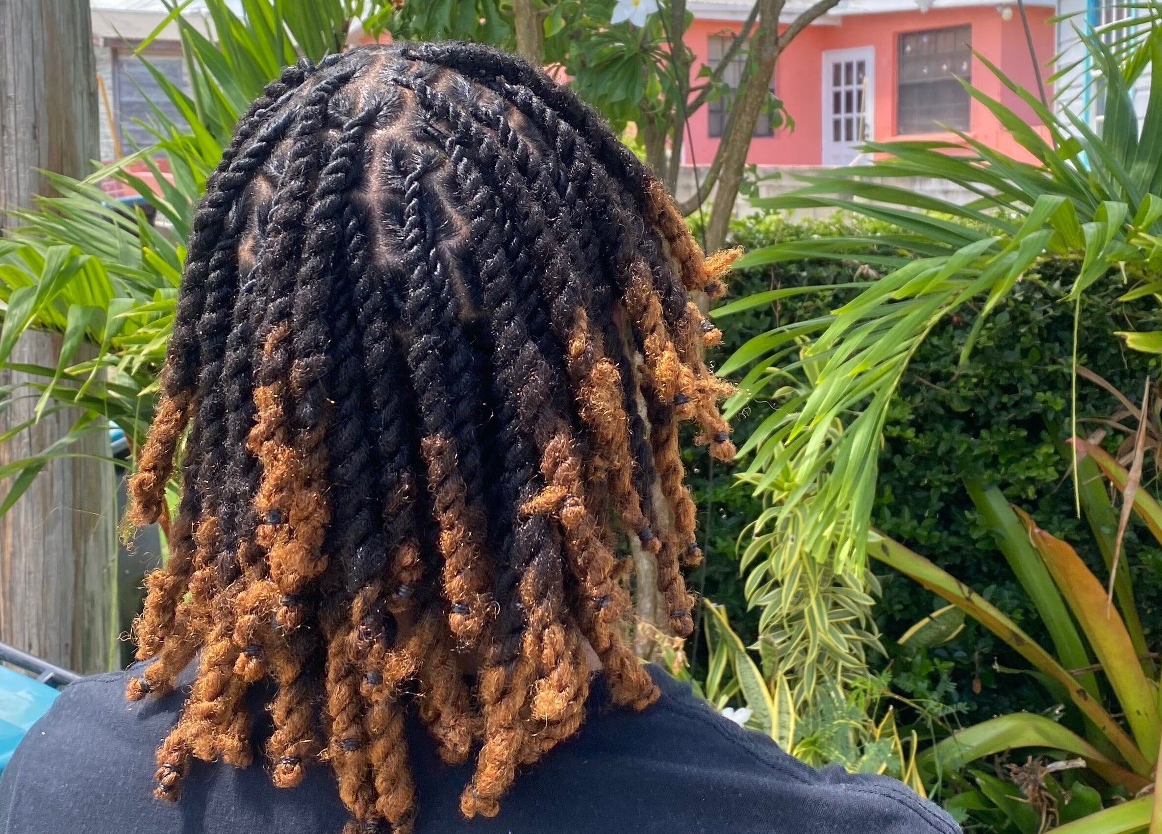 Stylish twists hairdo at Flux Beauty, Oistins, Christ Church, BB, surrounded by lush greenery.