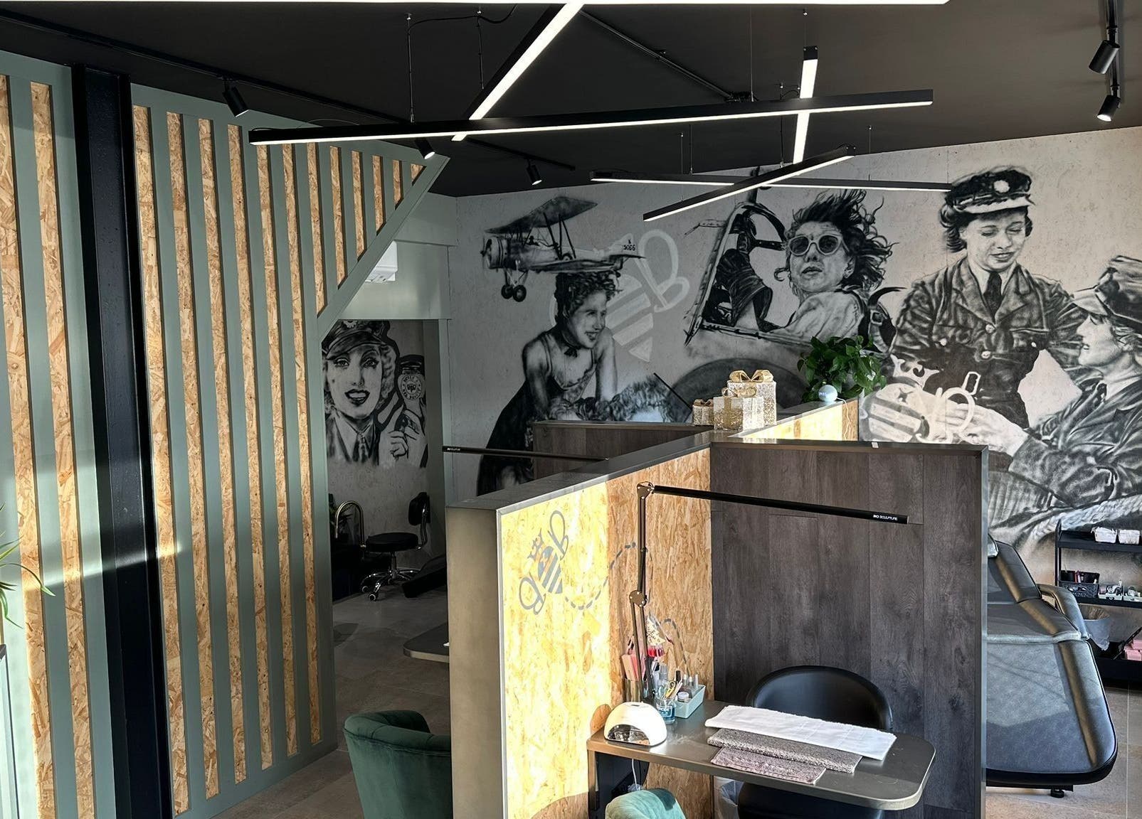 Artistic interior of Belle & Bee Beauty X Henlow at Henlow Camp, England, GB with creative murals and seating.