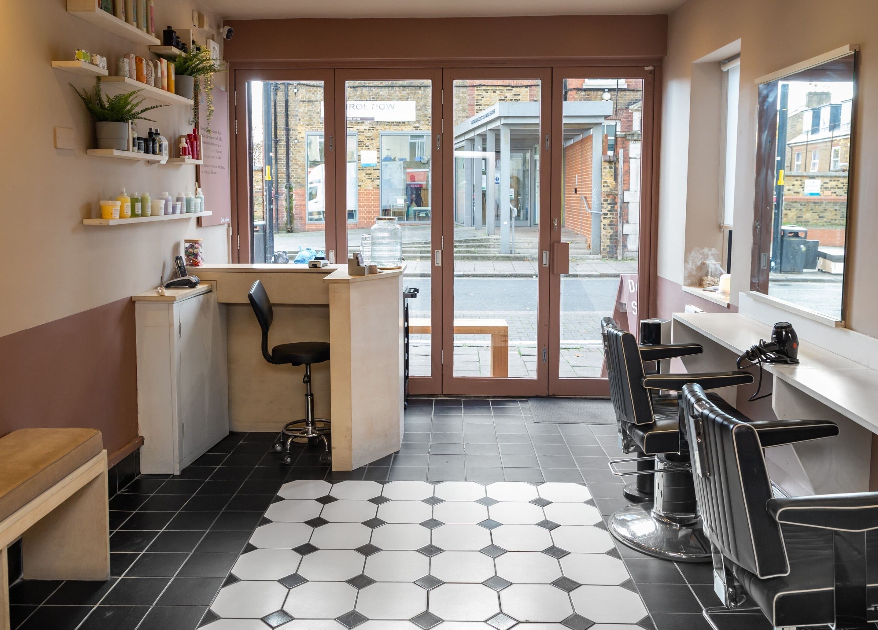 Chic and modern interior of De.Salons Peckham in London, England, GB, featuring stylish chairs and sleek design.