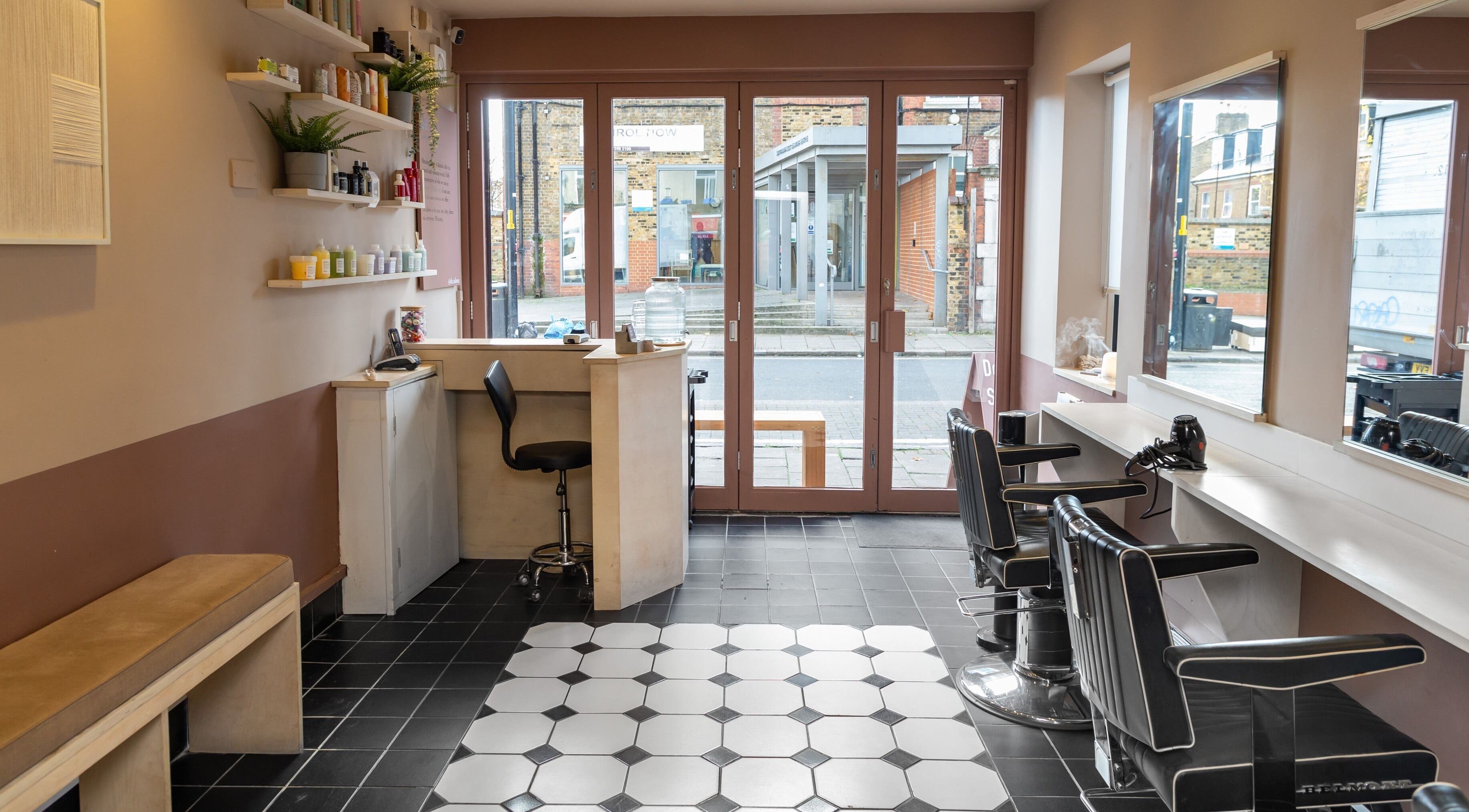 Chic and modern interior of De.Salons Peckham in London, England, GB, featuring stylish chairs and sleek design.