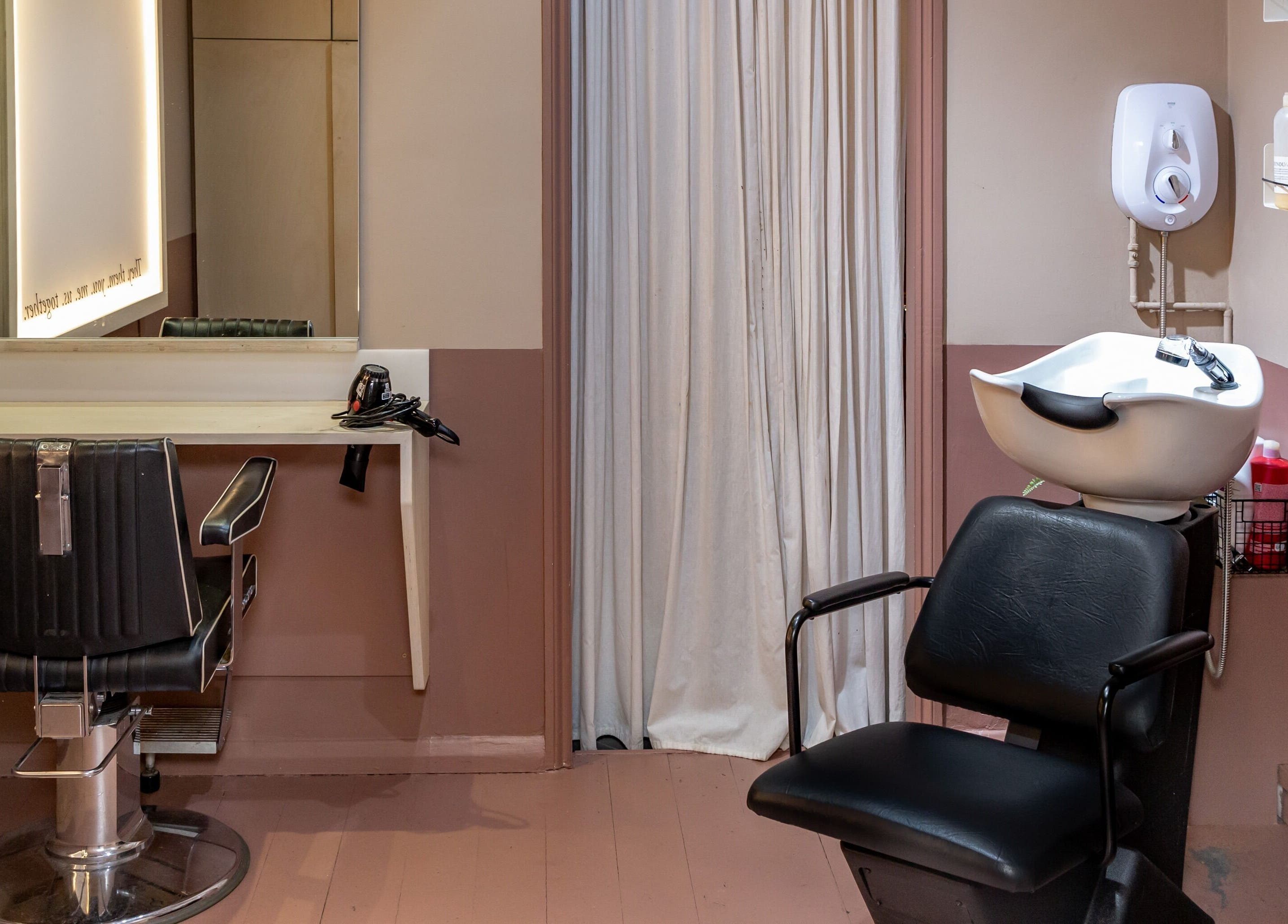 A chic hair station at De.Salons Peckham, London, England, GB, featuring a styling chair and sink.